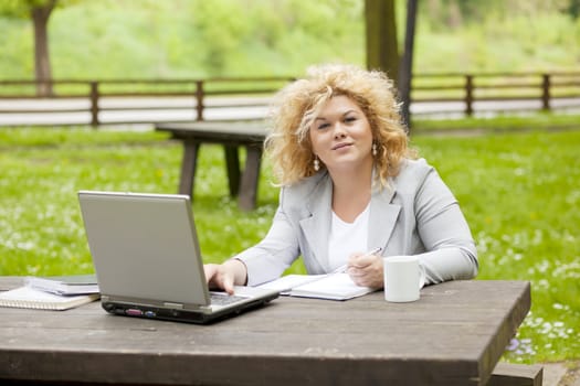 Young woman using laptop in park