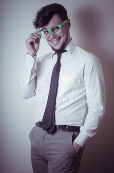 sexy stylish businessman with green eyeglasses on gray background