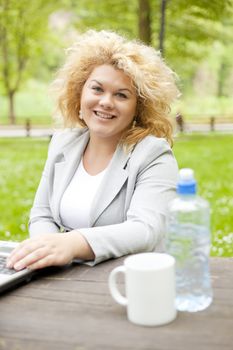 Young woman using laptop in park