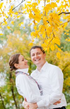 Portrait of romantic happy young beautiful couple on autumn walk. Vertical view