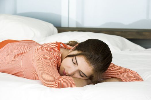 Portrait of a beautiful woman lying on a bed and sleeping 