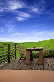 Beautiful outdoor space with a table and chairs and in the beackground a beautiful green meadow