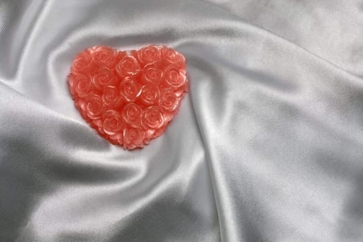 Heart-shaped candle on white satin, with space for text