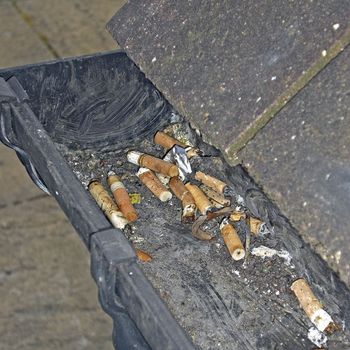 Cigarette butts in gutter.