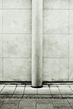 Modern stone pillar against a wall in monochrome
