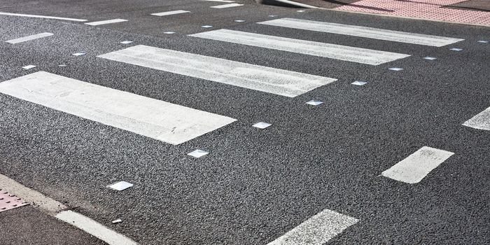 Details of a pedestrain crossing on a tarmac road