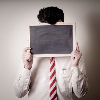 businessman with a blank blackboard on face on gray background