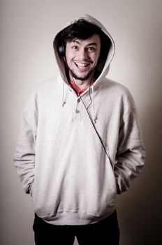 boy with sweatshirt and headphones on gray background 