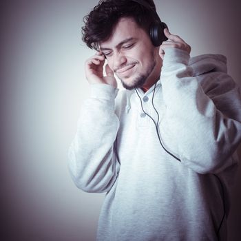 boy with sweatshirt and headphones on gray background 