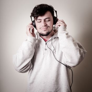 boy with sweatshirt and headphones on gray background 