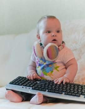 Portrait of baby in t-shirt with keyboard