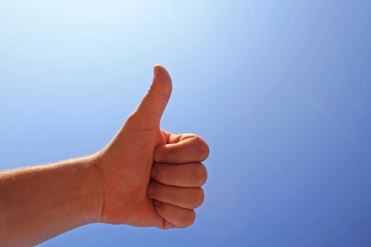 men's hand make thumbs up on blue sky