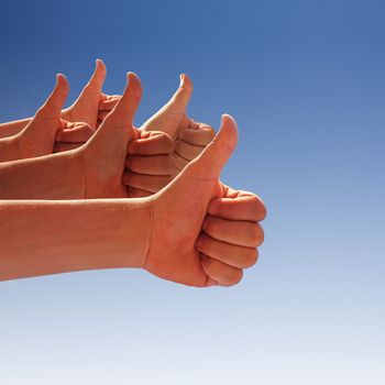 men's hands make thumbs up on blue sky