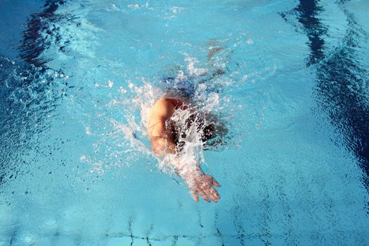 man swims in swimming pool