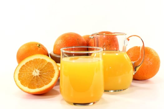 a glass of orange juice and fresh oranges