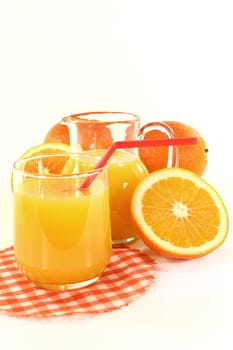 a glass of orange juice and fresh oranges