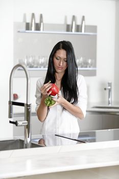 Beautiful young woman preparing food in her modern kitchen at home