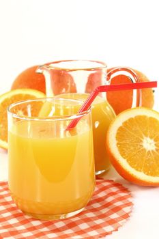a glass of orange juice and fresh oranges