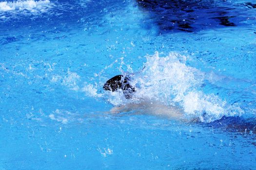 man swims in swimming pool