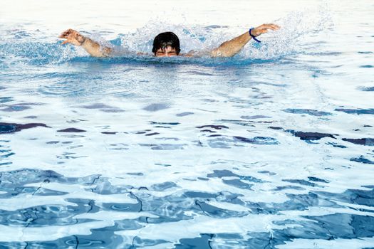 man swims in swimming pool