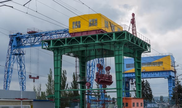 Lifting crane of the hydroelectric power plant on a dark and cloudy sky.