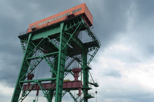 Lifting crane of the hydroelectric power plant on a dark and cloudy sky.