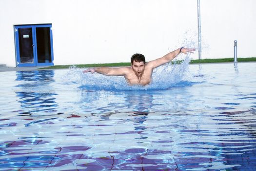 man swims in swimming pool