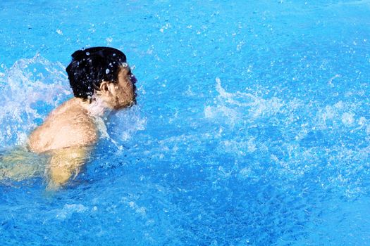 man swims in swimming pool