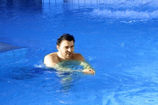 man swims in swimming pool