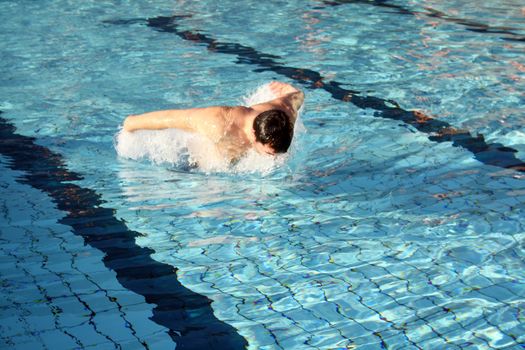 man swims in swimming pool