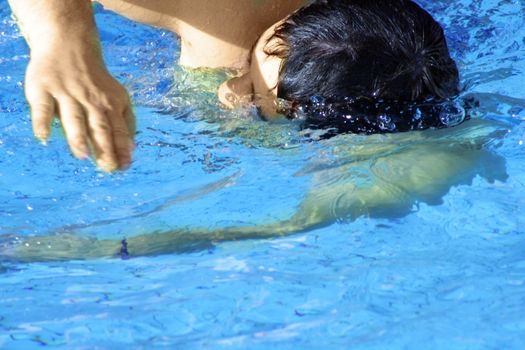 man swims in swimming pool