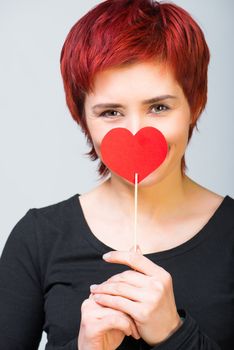 young woman with a red paper heart