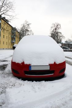 red car in city street in winter  