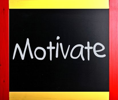 "Motivate" handwritten with white chalk on a blackboard