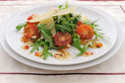 Spicy salad of arugula and cherry tomatoes with parmesan sauce