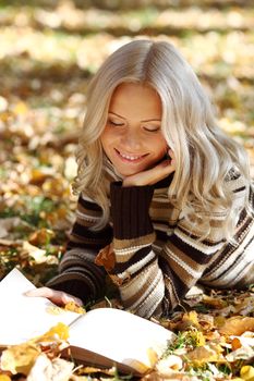 woman read the book in autumn park