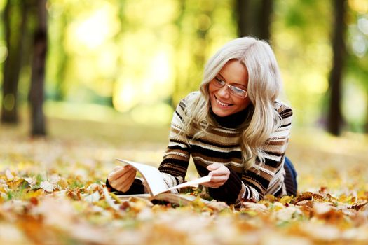 woman read the book in autumn park