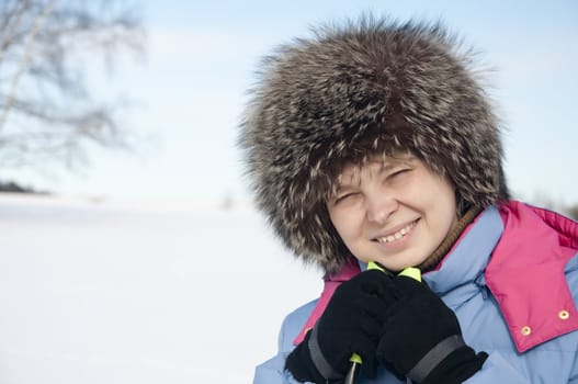 Woman tourist skier in snowy forest with ski poles