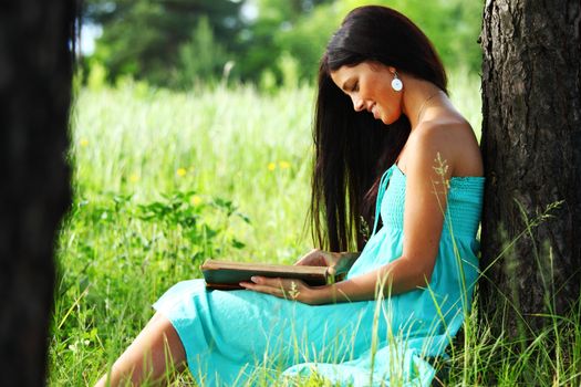 girl with book under big tree