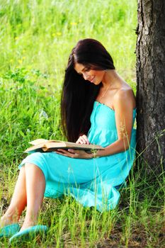 girl with book under big tree