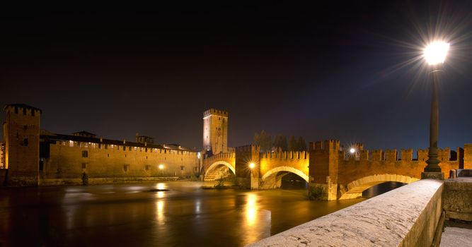 Castelvecchio - Scaliger bridge and Adige river at night in Verona - Italy
