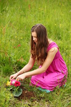 girl grow flower on green field