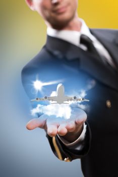 pilot in the form of extending a hand to a flying airplane with sky, clouds and sun