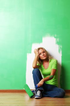 woman paints the wall brush