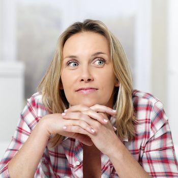 beautiful pensive blond woman at home on sofa