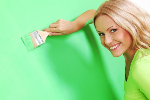 woman paints the wall brush
