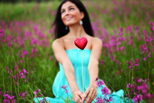 woman on flower field heart in hands