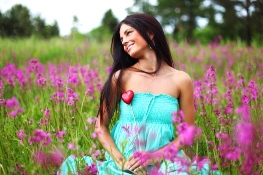 woman on flower field heart in hands