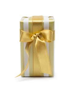 Gift box in gold duo tone with golden satin ribbon and bow isolated over white background.