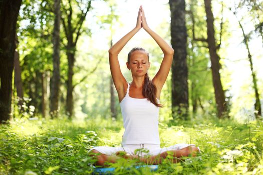 yoga woman on green grass in forest